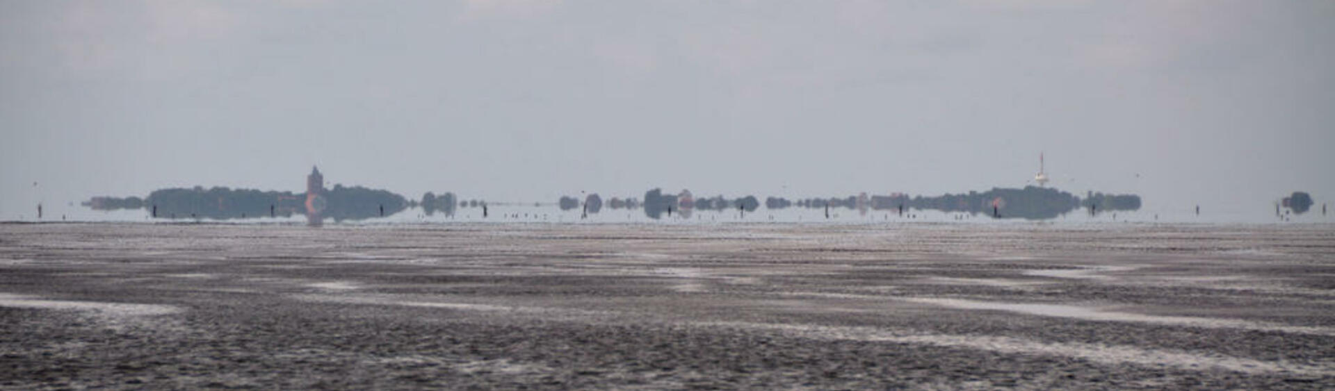 Exposed mudflats during low tide with the Island of Neuwerk on the distant horizon.