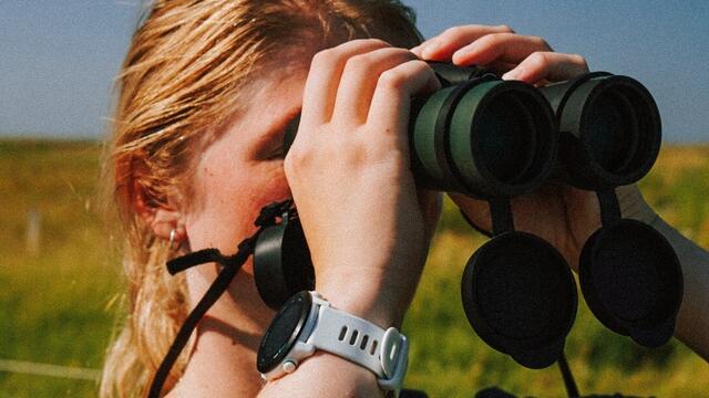 Young woman looking through binoculars. © Katharina Greitemann.