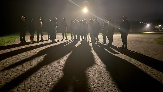 A group of people in front of a street lamp during night. © Jan-Willem van Kruyssen.