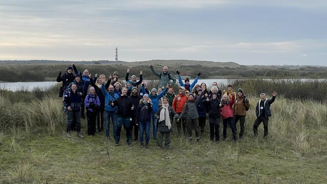 Participants of the 2024 IWSS workshop in the marshes with the Ameland lighthouse in the background. © CWSS/ Bostelmann.